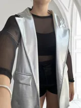 Chaleco largo plateado con textura simil piel de reptil, solapas y bolsillos delanteros.