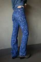 Pantalón de jean de corte recto con estampado de hojas en tonos azules.