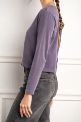 Remera color marrón de algodón peinado, corte oversize, cuello redondo y manga larga.