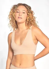 Top tipo soutien sin costuras, color beige, confeccionado en tejido rib elástico. Presenta escote en V profundo y breteles anchos fijos. Incluye copas desmontables.