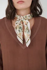 Blusa azul marino de corte recto y holgado, con escote en V y mangas largas. Presenta detalles de costuras a la vista en color blanco en el escote, puños y ruedo.