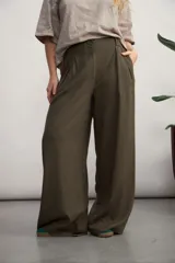 Pantalón de corte sastrero y pierna ancha, con pinzas delanteras y bolsillos laterales. Presenta un diseño de tiro alto con cierre frontal y cintura estructurada.