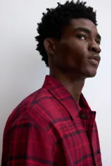 Pijama de dos piezas confeccionado en franela de algodón. Incluye una camisa de manga larga con cuello inglés, botones frontales y bolsillo en el pecho, junto con un pantalón de corte recto con cintura elástica y cordón ajustable.