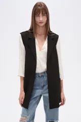 Chaleco largo de corte recto y diseño abierto, con solapas clásicas y bolsillos laterales. Confeccionado en poliéster, presenta una caída fluida y un estilo versátil ideal para superposiciones.