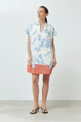 Túnica corta color blanco con estampado floral celeste y base color salmón.