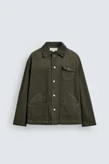 Cazadora relaxed fit de algodón color verde militar, con efecto lavado, cuello solapa de pana a tono y manga larga. Cuenta con bolsillos de plastrón delanteros y cierre frontal de botonadura.