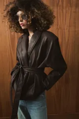 Chaqueta de Zara Woman Collection confeccionada en tejido efecto piel con textura granulada. Presenta cuello solapa, manga larga y cierre frontal con cinturón ajustable mediante lazada. Incluye forro interior.