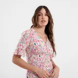 Vestido corto con estampado floral en tonos rojos y celestes, con escote en V y mangas cortas acampanadas.