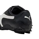 Championes Puma modelo Mostro Perforated, de diseño bajo con exterior de cuero perforado en color blanco y detalles en negro. Presenta una suela distintiva con relieve de tachones y cierre de velcro en el empeine.