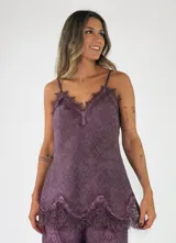 Top color lila con detalles de encaje en el escote y el ruedo, de tirantes finos y diseño fluido.