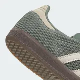 Championes Adidas Samba OG de diseño urbano, con exterior de malla y cuero en tono verde oliva. Presenta las icónicas tres tiras laterales en color crema, talón reforzado y suela de caucho color marrón.