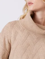 Buzo de punto grueso con textura en relieve, de cuello volcado y mangas largas con hombros caídos. Presenta puños y ruedo con terminación en rib.