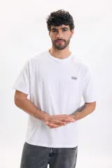 Camiseta blanca de manga corta y corte relaxed, con pequeño estampado tipográfico en el pecho.