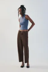 Jeans de tiro medio color marrón con diseño de volumen crop, silueta holgada en las piernas y cinco bolsillos tradicionales. Cierre frontal con cremallera y botón metálico.