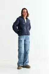 Campera puffer de corte recto con cierre frontal, capucha integrada y diseño acolchado horizontal.