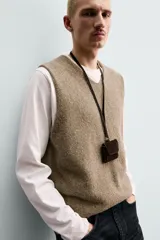 Chaleco regular fit de punto tejido en hilatura con mezcla de lana, color marrón con efecto melange. Cuenta con cuello en V y manga sisa, con acabados acanalados.