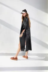 Tapado largo de cuero negro, con aberturas en los costados y en las mangas.