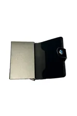 Billetera negra de cuerina con cierre de botón a presión, que incluye un compartimento metálico para tarjetas con sistema de expulsión.