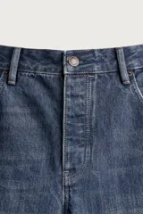 Jeans flare fit de denim azul oscuro con roturas y costuras decorativas en las perneras. Tiro medio y diseño de cinco bolsillos.