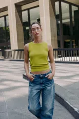 Top de punto color amarillo mostaza, con cuello redondo y manga sisa. Acabados en rib a tono.