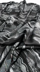Vestido corto ajustado de color negro y gris con estampa digital abstracta, cuello halter y detalle de frunce regulable en el lateral de la falda.