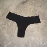 Tanga de algodón negro con detalle de puntilla fina en la cintura.