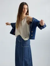 Chaqueta de jean azul oscuro, de corte corto y entallado, con cuello y solapa, y botones de madera en el frente.