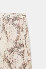 Pantalón de tiro medio con estampado animal print tipo serpiente. Presenta un diseño de bajo abullonado ajustable mediante lazadas y detalle de hilo metalizado. Cuenta con cierre lateral con cremallera oculta.