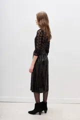 Falda midi de corte evasé, confeccionada en tela negra cubierta completamente de lentejuelas brillantes. Presenta una cintura elástica cómoda y un diseño fluido que aporta movimiento.