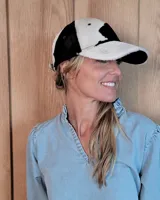 Gorra tipo visera confeccionada en cuero con textura de pelo, diseño clásico con ojales metálicos de ventilación y ajuste posterior.