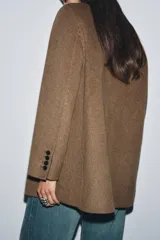 Blazer oversize de Zara Woman Collection confeccionado en mezcla de lana, con cuello sin solapa, manga larga y cierre frontal con botón. Presenta bolsillos delanteros con solapa.