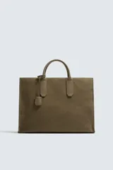Bolso tipo bandolera de piel con acabado abatanado, diseño rectangular con doble asa de mano y detalle de llavero colgante. Cuenta con compartimento principal con cierre de mosquetón y bolsillo interior con cremallera.