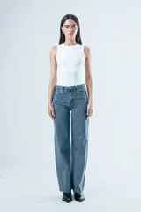 Jean de corte wide leg, confeccionado en denim azul con estampado de pequeños puntos blancos. Presenta tiro alto, cierre frontal con botón y bolsillos laterales y traseros.