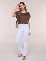 Pantalón jean de tiro medio y calce bootcut color blanco, confeccionado en denim elastizado con visibles pespuntes decorativos a contraste en pretina, bolsillos frontales y traseros. Presenta bolsillos posteriores con botón metálico y cierre frontal con cremallera y botón.
