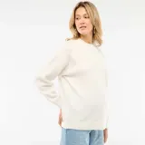Sweater de punto color blanco con cuello redondo, mangas largas y detalle de flores bordadas tono sobre tono en la parte superior.