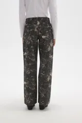 Pantalon de jean de corte ancho y tiro bajo, con estampado abstracto en tonos oscuros.