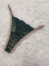 Microtanga con frente de encaje verde oscuro con diseño ornamental y laterales regulables en color beige.