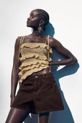 Shorts de jean color marrón oscuro, de tiro medio y corte mom fit. Con cinco bolsillos, cierre frontal con cremallera y botón.