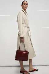 Bolso formato mini shopper de piel con acabado brillante y efecto arrugado. Cuenta con doble compartimento, cierre mediante botón imantado, bolsillo interior y asa de hombro ajustable.