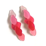 Par de aros colgantes con piezas de acrílico traslúcido en forma de pétalos irregulares, en degradé de rosa y rojo.