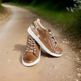 Championes de cuero color terra con diseño pintado a mano en el talón, cordones claros y suela de goma blanca.