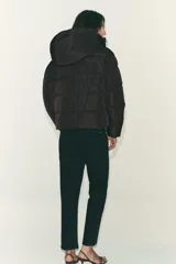 Anorak acolchado de corte corto, resistente al agua y al viento. Cuenta con cuello subido, capucha ajustable con cordones, cierre frontal con cremallera y bolsillos laterales con forro polar. El bajo es ajustable mediante cordones elásticos.