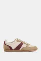 Championes de estilo running con diseño de paneles combinados en cuero y serraje. Presenta una base en tono crema con detalles en color bordó y refuerzos en gamuza color tostado. Cuenta con cierre mediante cordones y punta redonda.