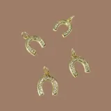 Capa de paño color rojo con corte amplio y caída natural. Presenta detalles de dijes metálicos en baño de oro distribuidos en la espalda y una etiqueta de cuero con el logo de la marca en la parte superior.