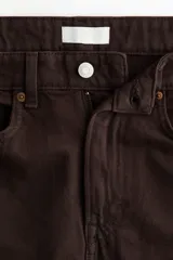 Bermuda de cinco bolsillos en denim de algodón rígido, de tiro alto con cierre y botón, en color marrón.