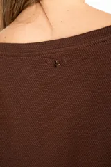 Sweater de manga larga color café, con textura gofrada y cuello redondo. Presenta una fina línea decorativa de color beige en el exterior de ambas mangas.