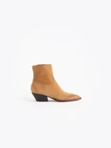 Bota de caña baja confeccionada en cuero descarne color marrón, con diseño de punta fina y tacón bajo de madera.