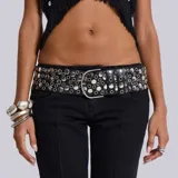 Cinto negro ancho de cuero sintético con hebilla plateada y apliques de círculos metálicos plateados de diferentes tamaños.