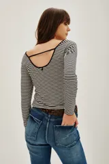Remera de manga larga con diseño de rayas horizontales finas en blanco y negro, confeccionada en tejido suave y elástico.