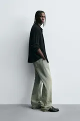 Camisa de hombre de corte relaxed fit, color negro, con textura de cuadros en relieve. Presenta cuello solapa, manga larga con puño abotonado y cierre frontal de botonadura.